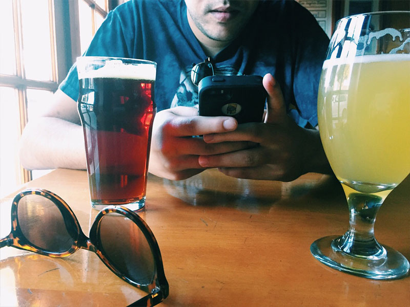 A man who's on a date with his girlfriend texting his ex.