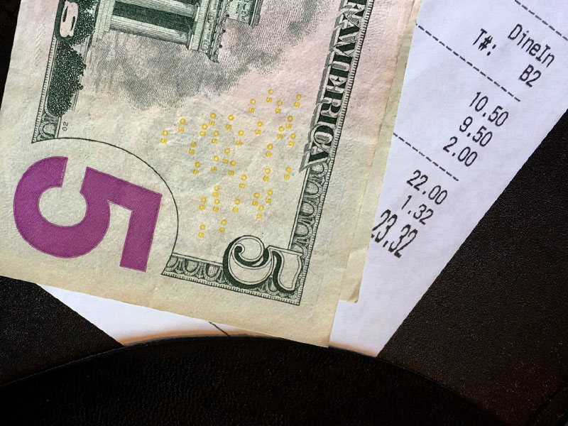 A tip on a table with a receipt.