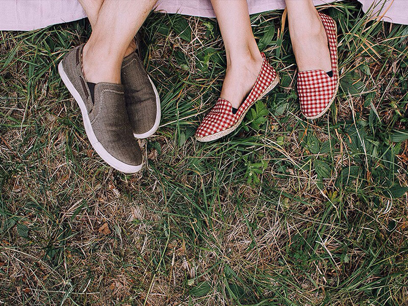 A couple's feet as they lay down on a picnic blanket on a first date.