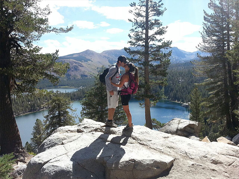 A couple kissing on a hike because it was a cheap first date idea for them.