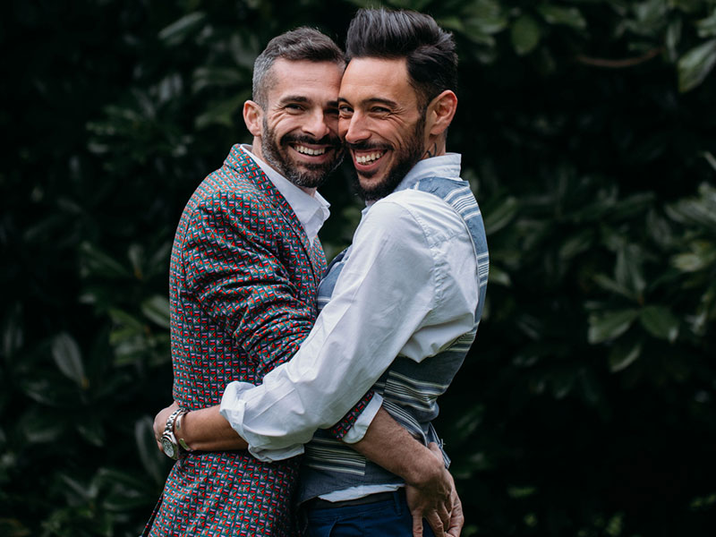 A happy couple of two men hugging.
