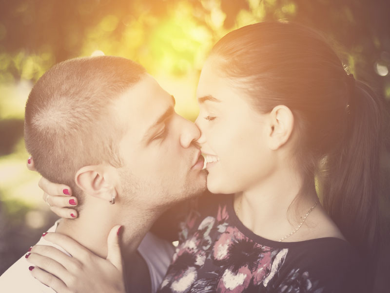 A couple in a healthy relationship about to kiss in the sun.
