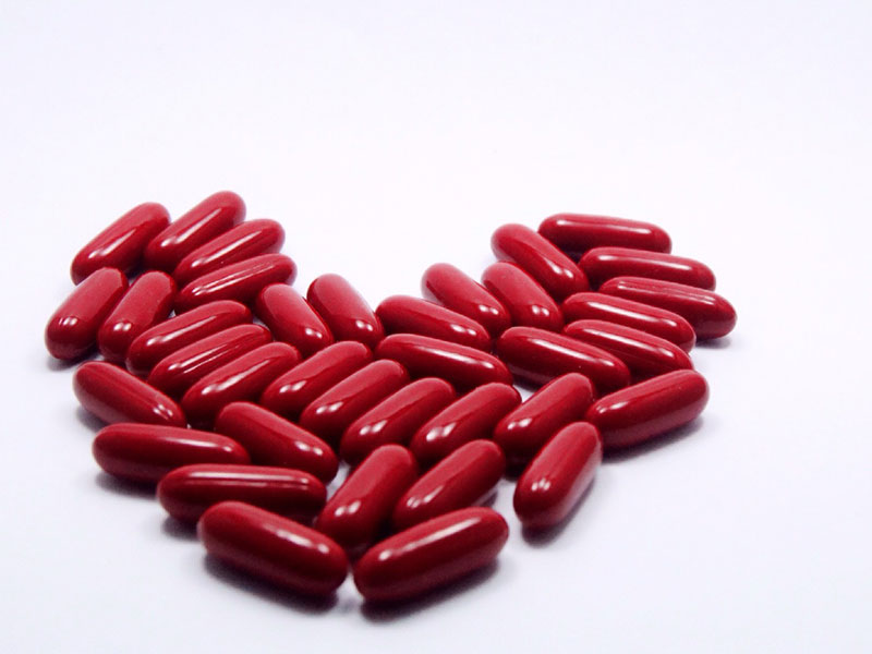 Red pills in the shape of a heart.