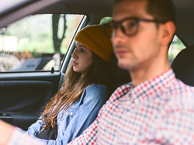 A couple in a car looking mad because they have relationship problems.