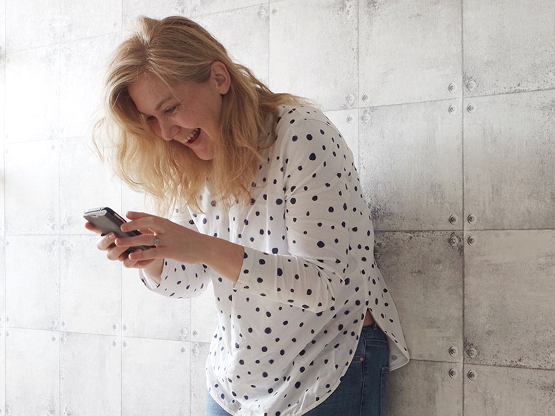 A woman sending flirty texts and laughing.