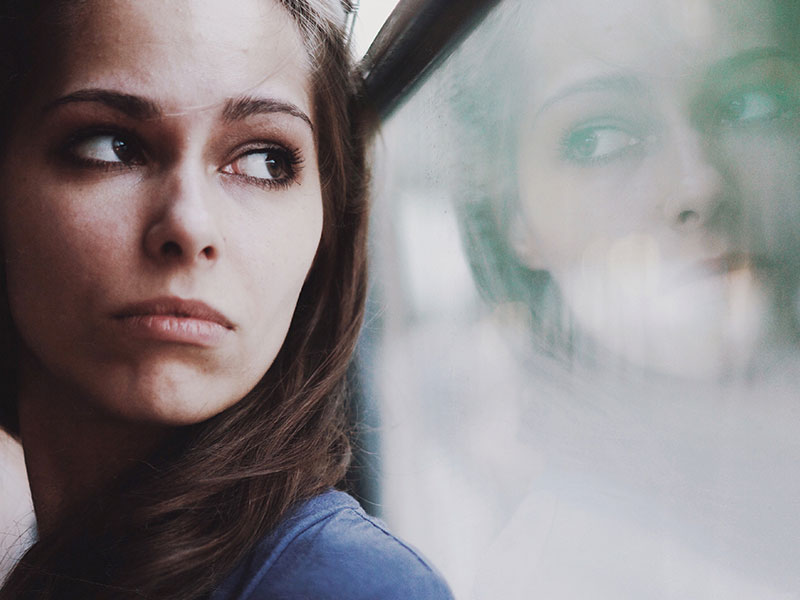 A woman looking out a window wondering how to know when to break up.