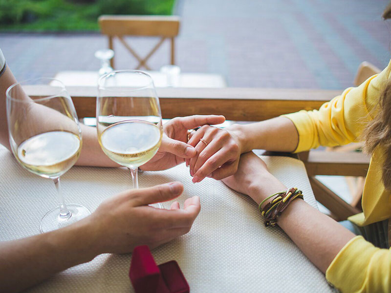 A couple's hands touching across a dinner table where they're dating after divorce.
