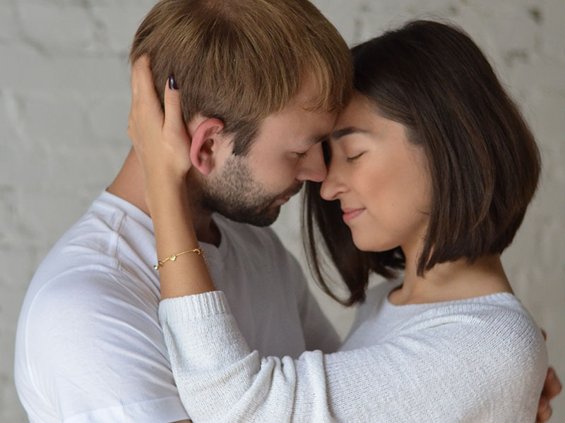 A couple who is used to breaking up and getting back together hugging with their eyes closed.