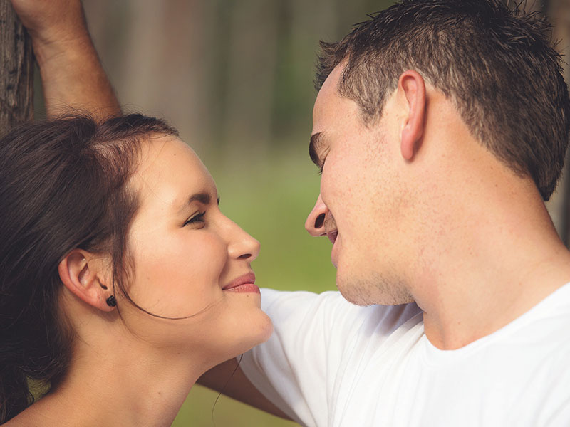 A girl who's rebound dating smiling as a guy hits on her.