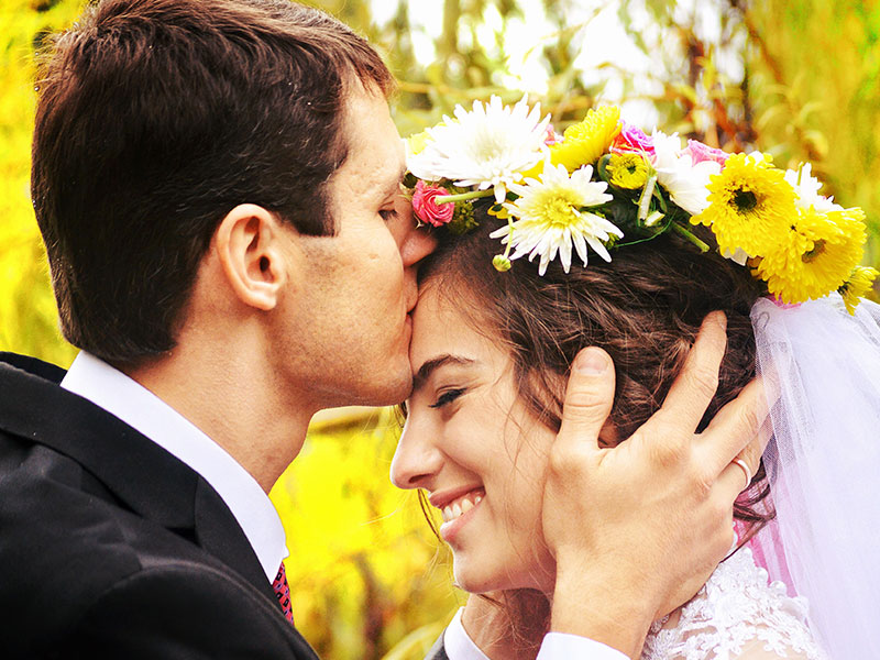A man giving a woman a forehead kiss.