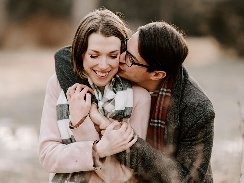 A couple who made common relationship mistakes kissing in a field.