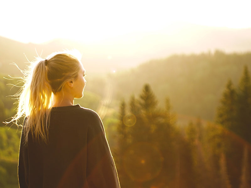 A woman thinking to herself I just want to be loved, while looking out over a mountain scene.