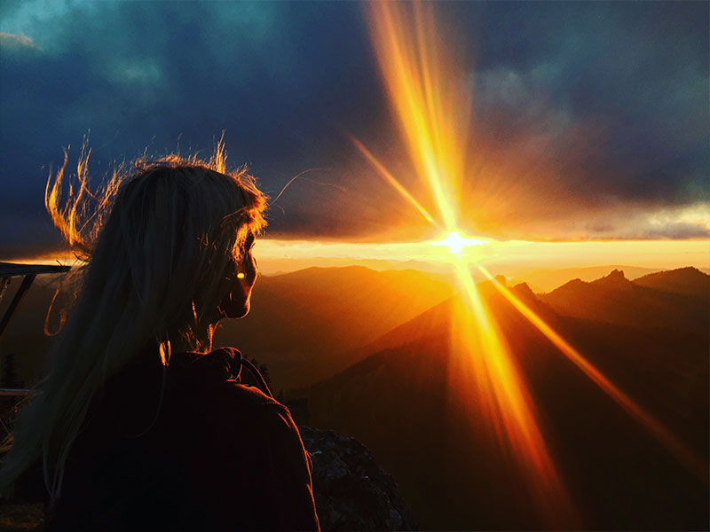 A woman looking at the sunset as she learns how to get over a breakup and move on stronger.