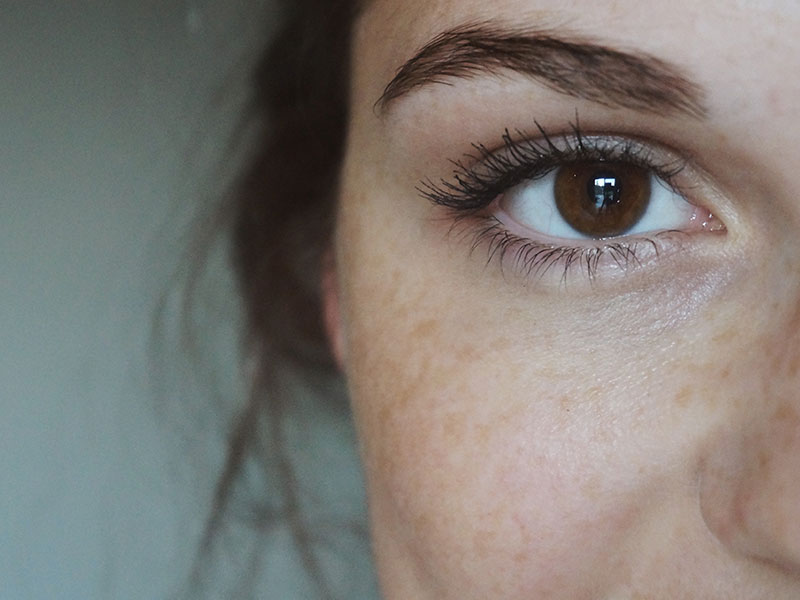 A woman looking at the camera grinning, while experiencing love at first sight.