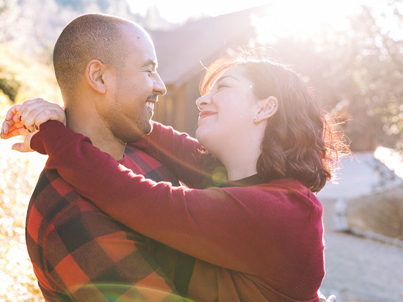A couple looking into each other's eyes and smiling like a real life love story.