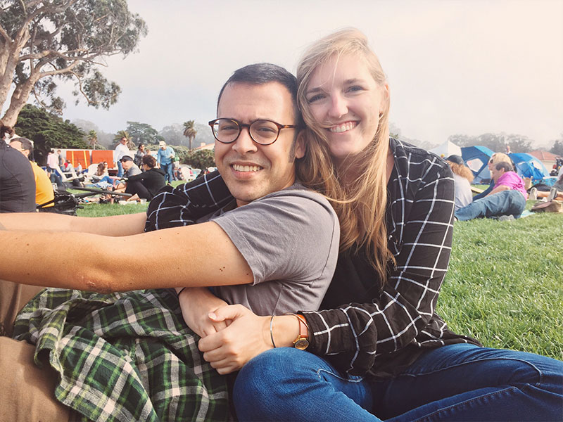 A couple dating in San Francisco at Dolores park hugging.