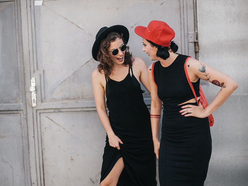 Two women who listened to these first date tips for modern daters laughing and talking on their date.