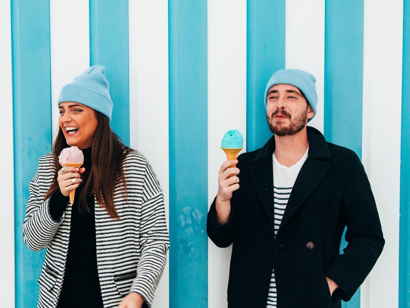 attractive couple laughing while eating ice cream