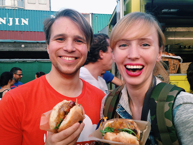 Two people who wanted to meet people offline, eating chicken sandwiches at a baseball game.