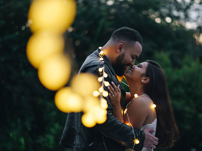 A couple who listened to these online dating tips, kissing under the lights in the new year.
