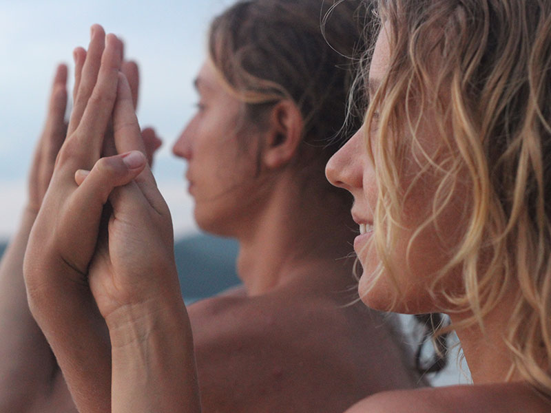 A couple in a healthy relationship holding hands on the beach, smiling.