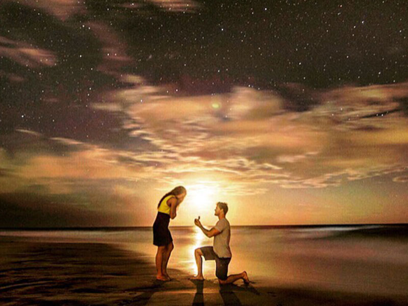 A woman who was wondering how do you know when you're in love, gasping while her boyfriend gets down on one knee and proposes.