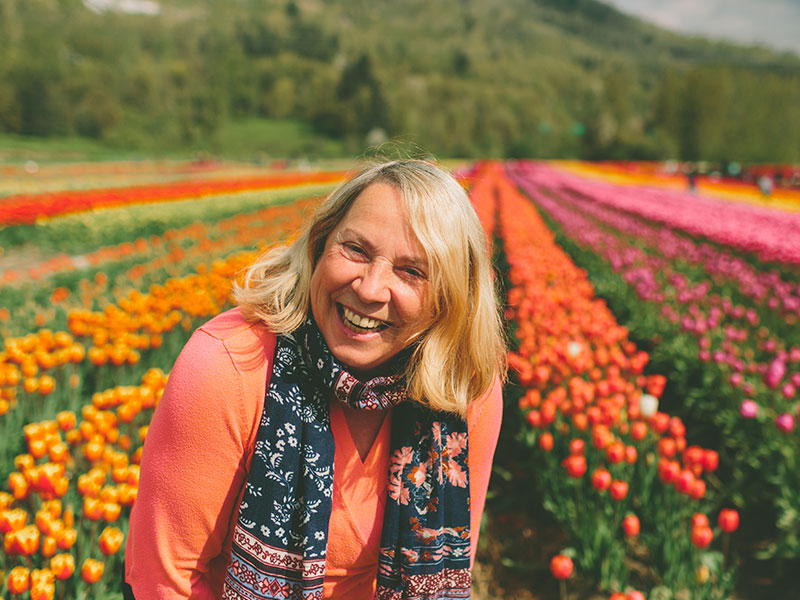 A woman who's learning how to get over a divorce laughing in a field of tulips.