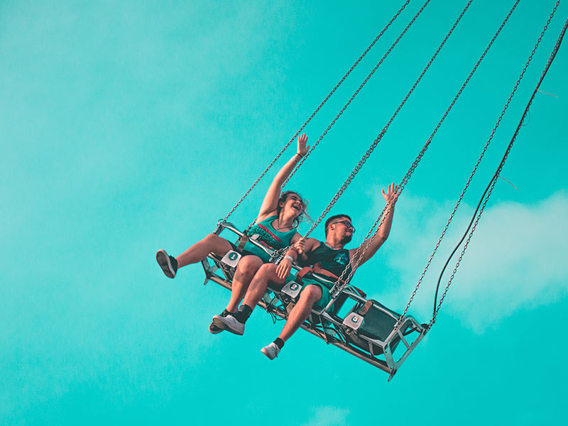 A couple on a amusement ride laughing and smiling on one of these best date ideas.