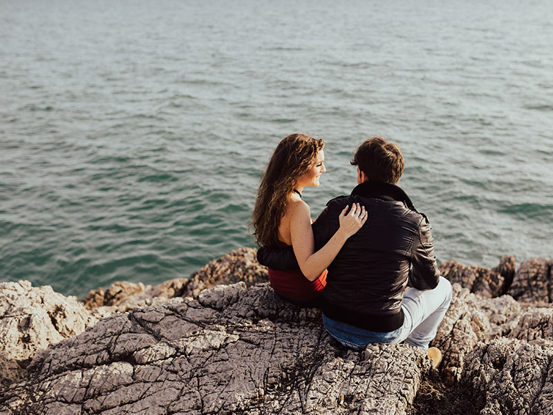 A guy who learned how to ask a girl to be your girlfriend talking to his girlfriend at the beach.