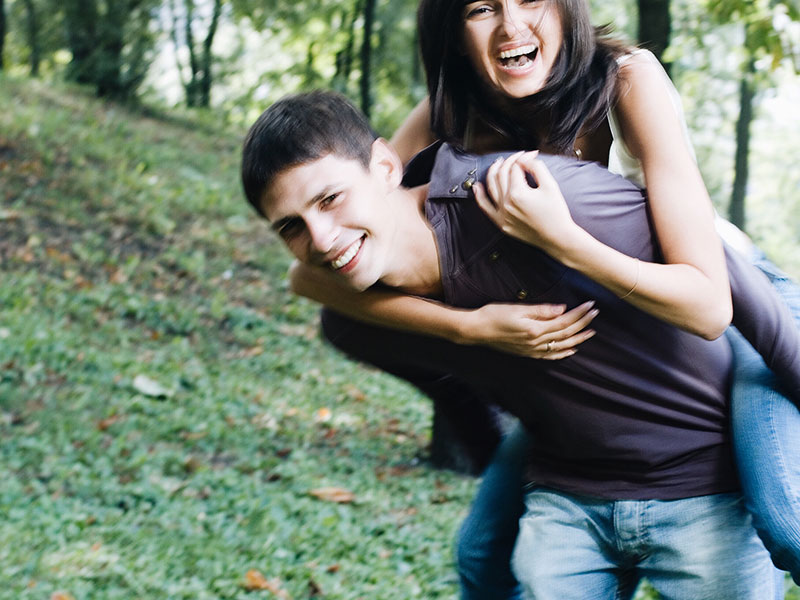 A guy with a girl best friend, carrying her on his back as they laugh and tease each other.