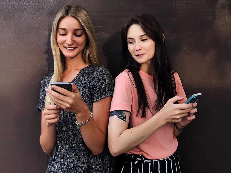 Two girls who are using these Tinder hacks to meet people on the app.