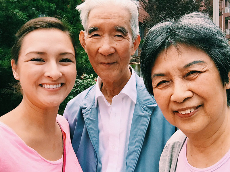A woman standing with her parents, about to meet her significant other.