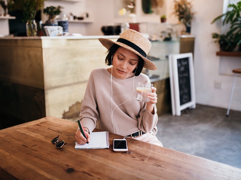 attractive lady sitting at table working out how to use dating profile headlines to attract guys