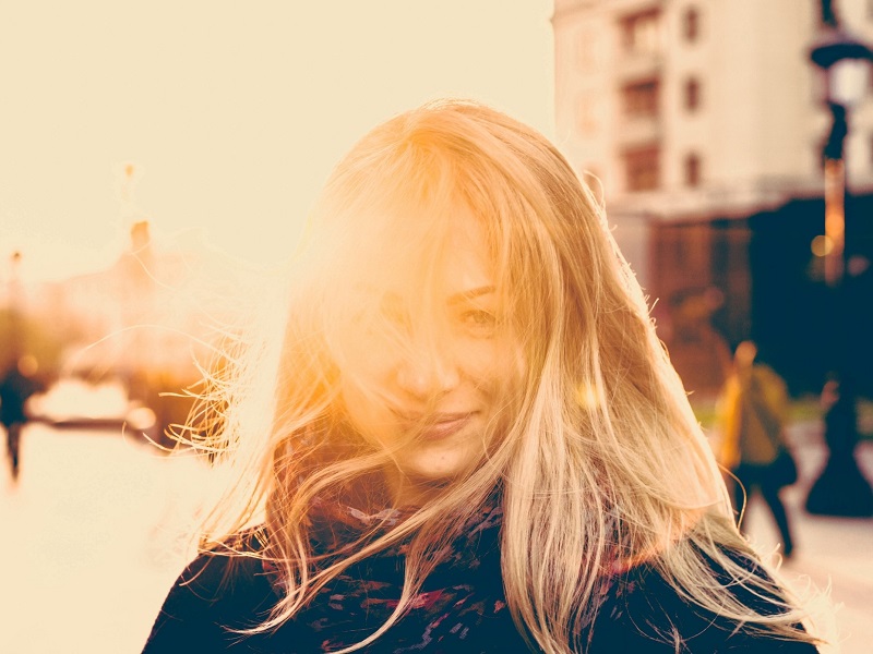 woman smiling in the sunshine inspired by positive divorce quotes