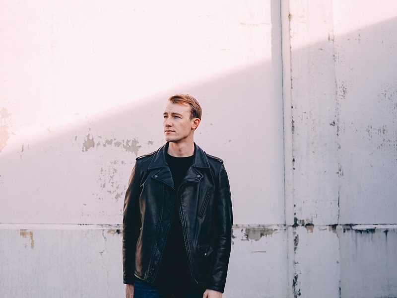 man standing in front of wall going through the stages of a breakup for men