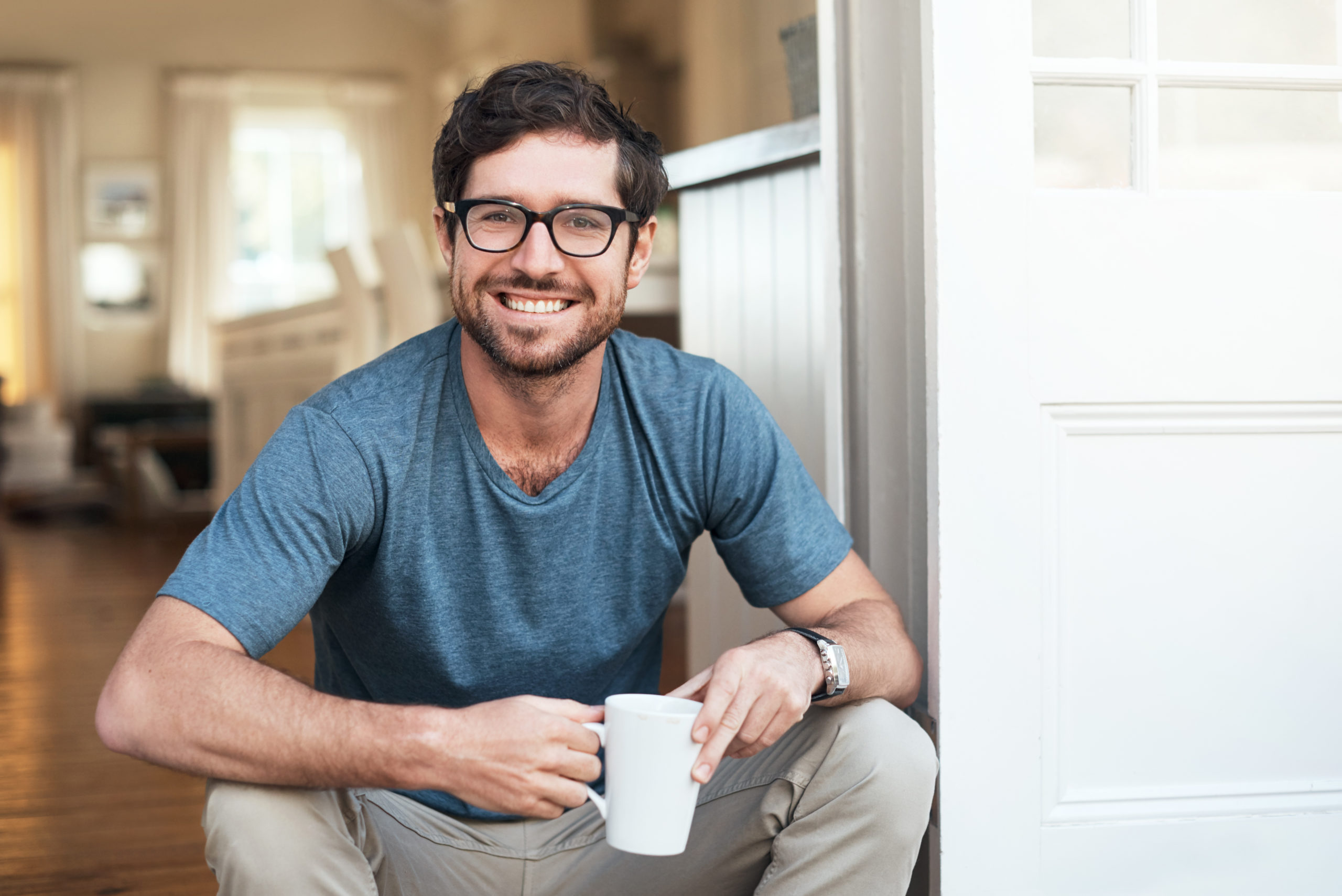attractive single man sitting on a step drinking coffee