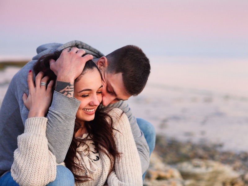 young couple in love and holding each other at the beach