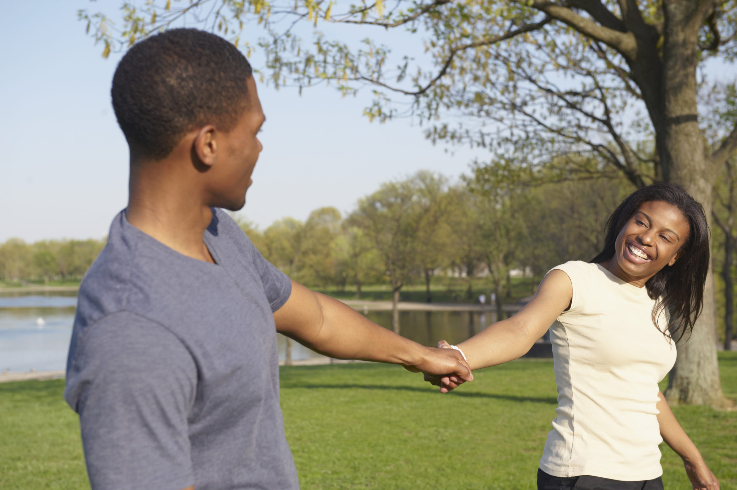 couple holding hands and laughing in park in Washington DC