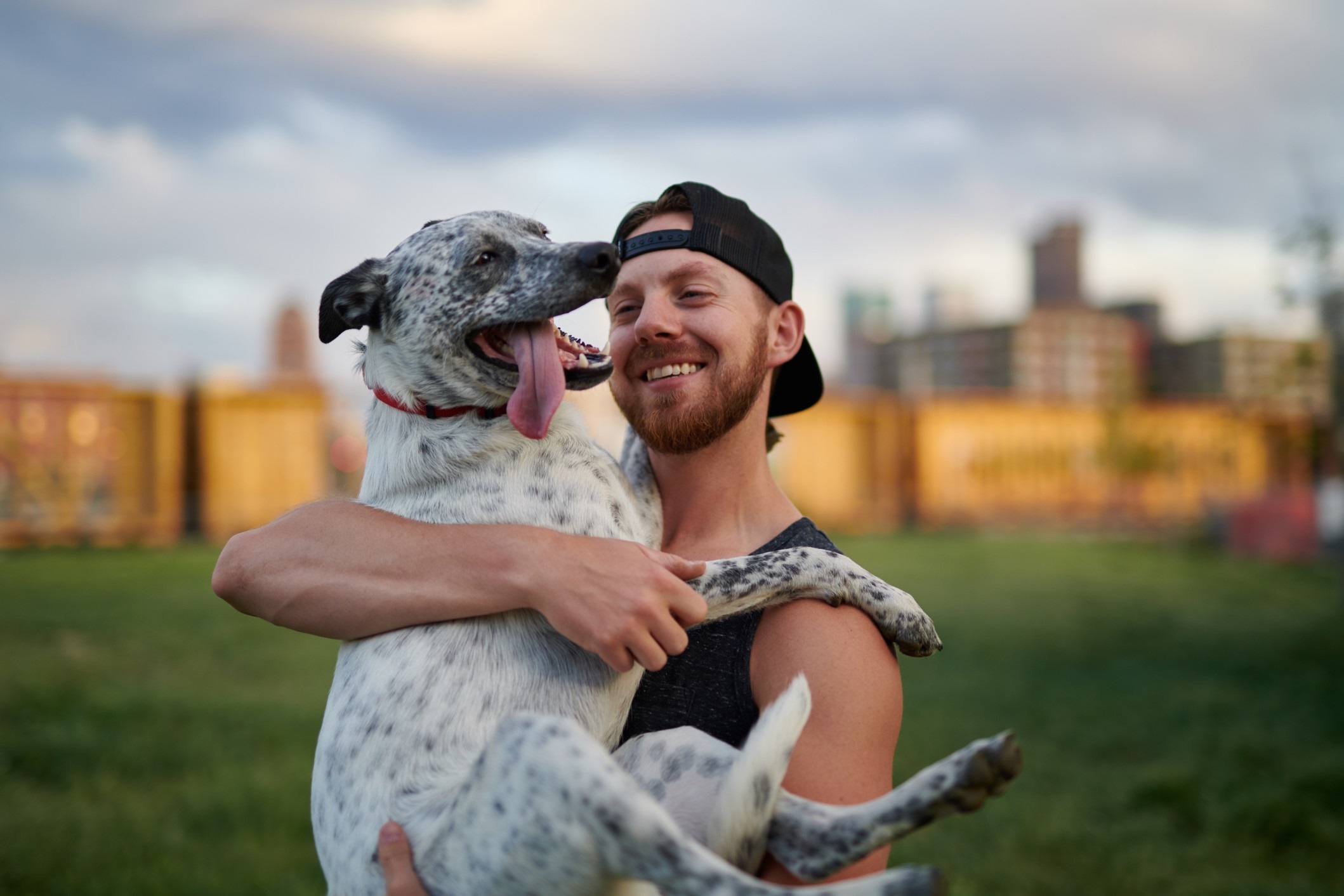 attractive single man in Denver smiling and holding his dog