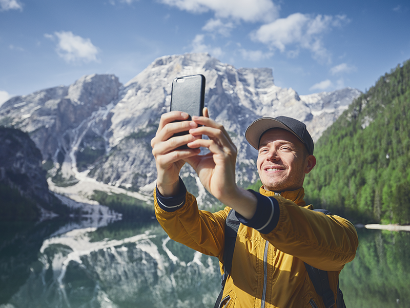 Man taking a selfie in the woods to use as his dating profile photo