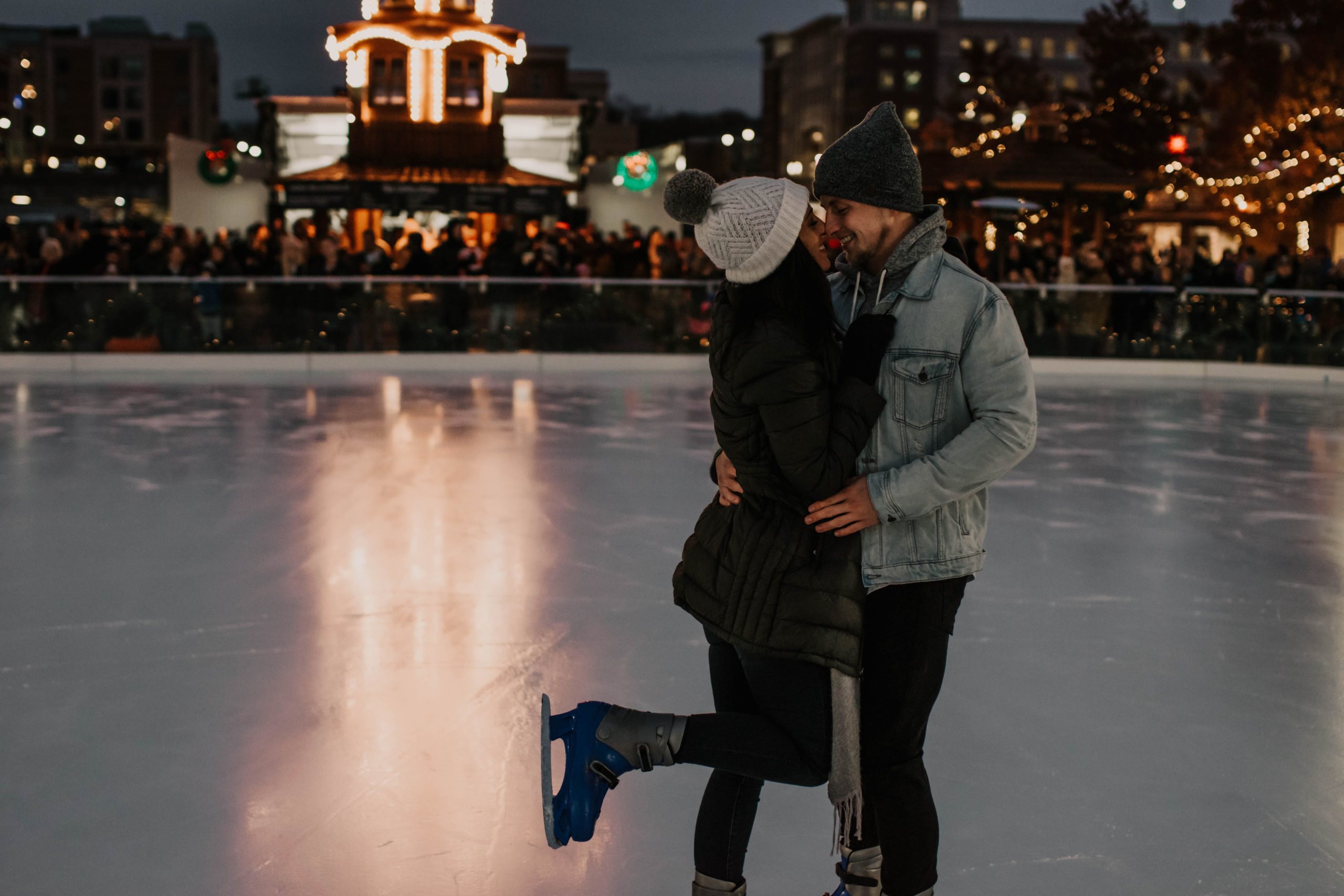 Happy couple embracing each other while ice skating and dating in Indianapolis.
