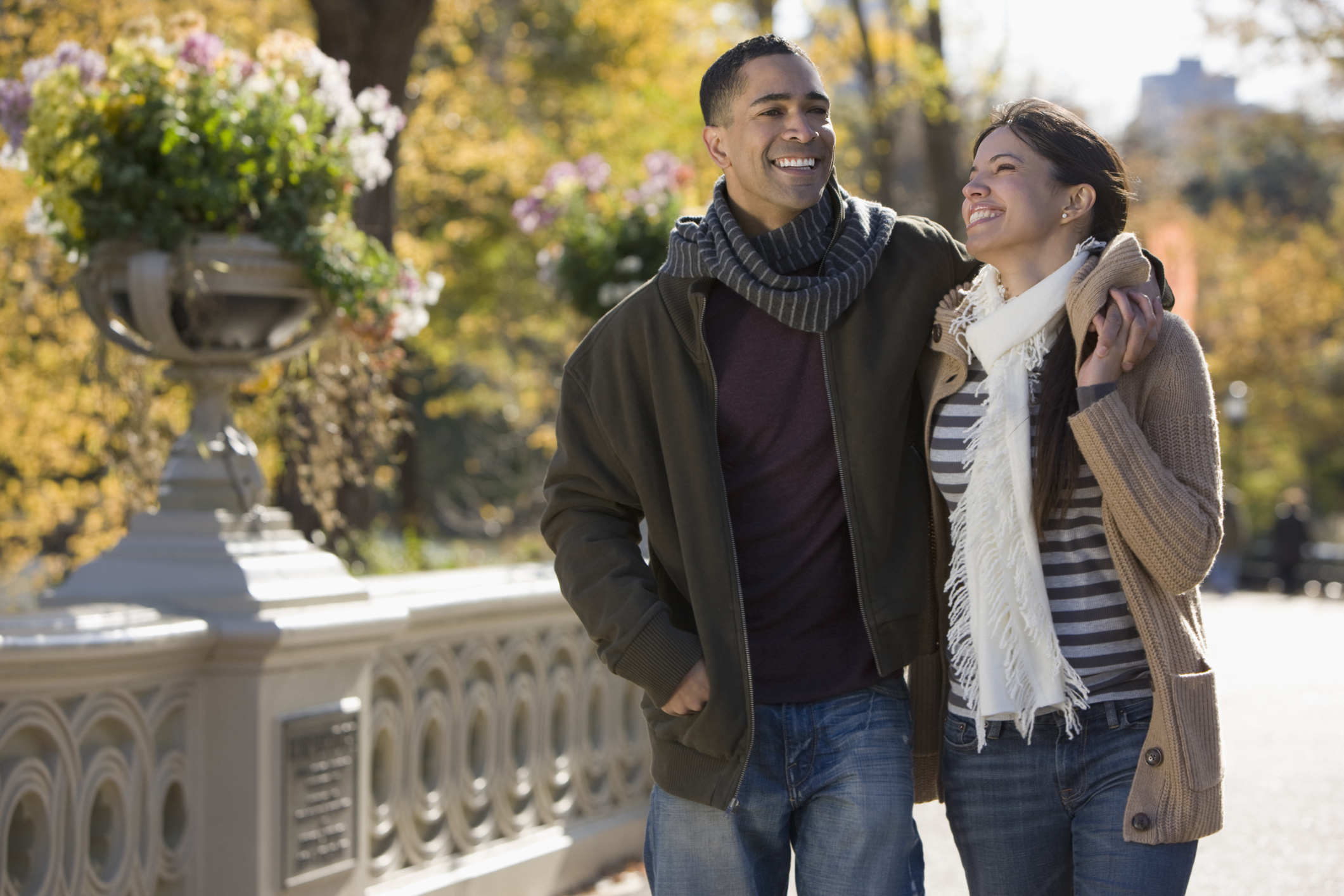 Happy, smiling couple walking together outdoors after meeting on a Latin dating site.