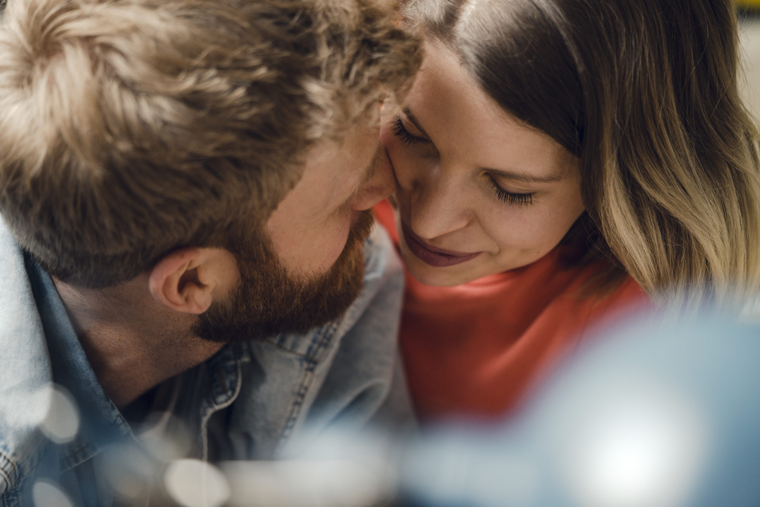 Affectionate couple cuddling at home while using the words of affirmation love language.