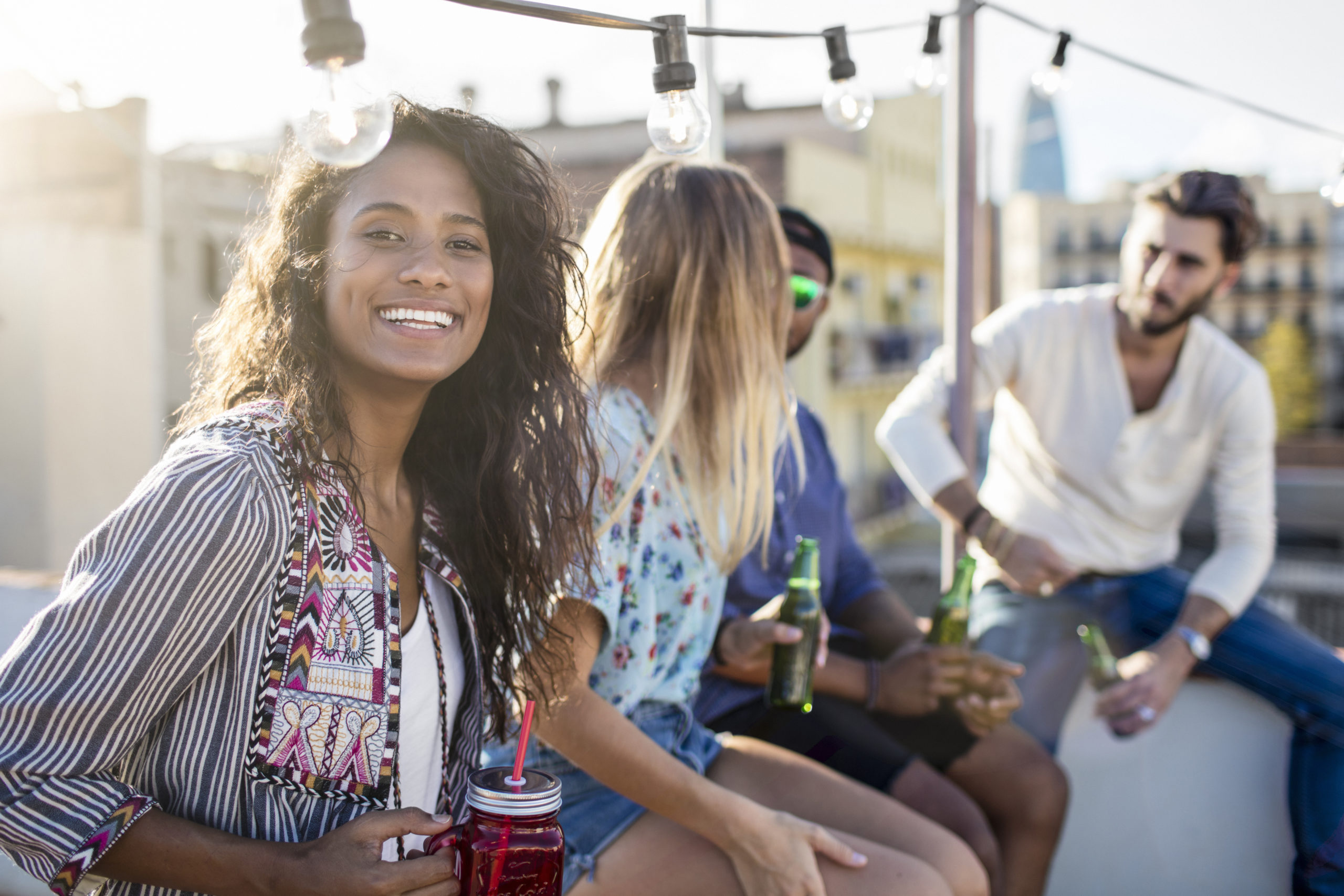 Woman looking towards camera and smiling while enjoying a singles dating event outdoors.