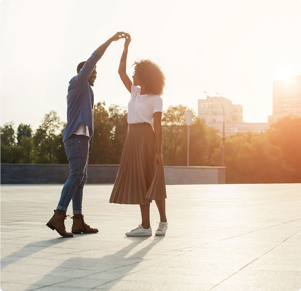 A man and woman are dancing in the sun